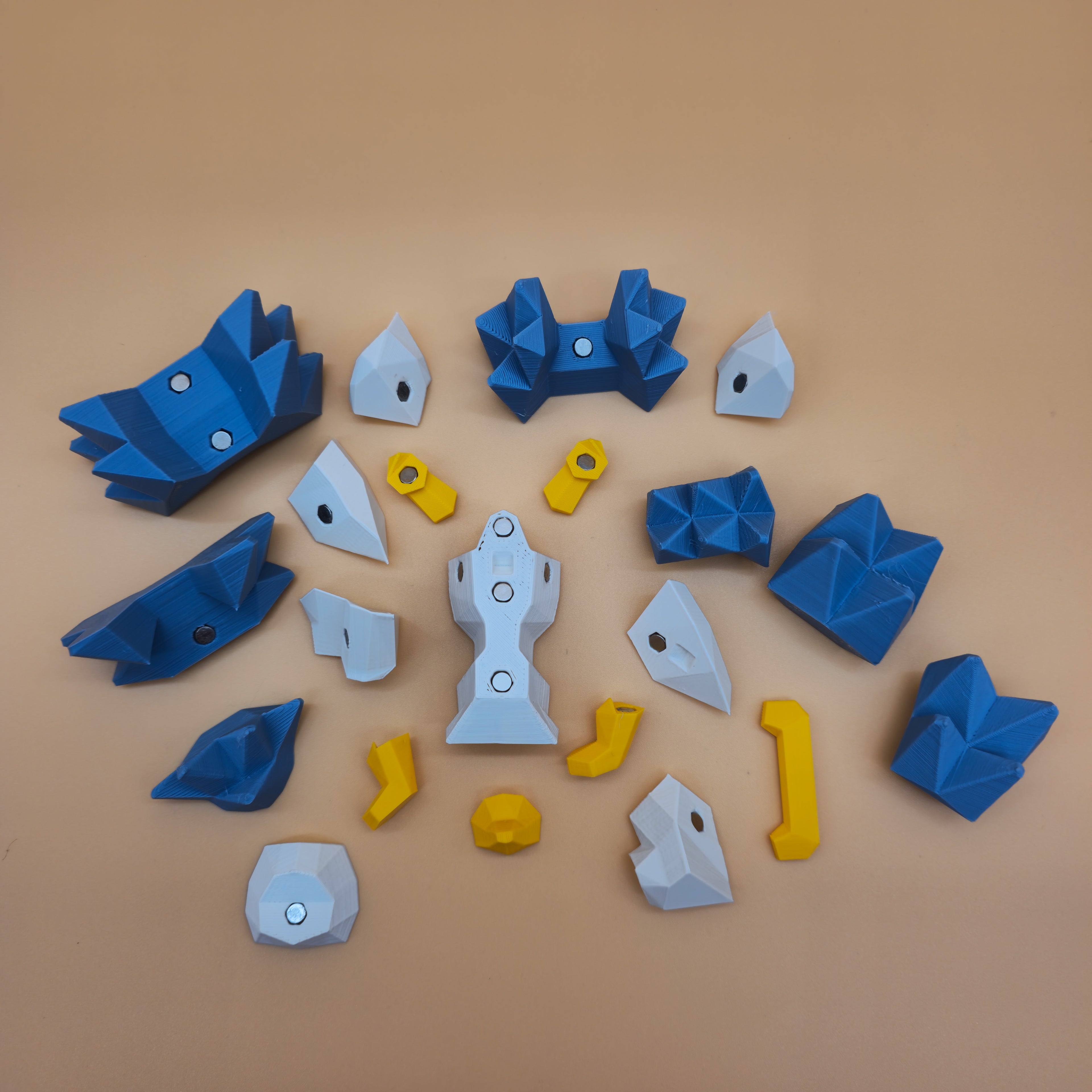 White, metallic blue, and yellow magnetic hedgehog puzzle pieces on a beige background