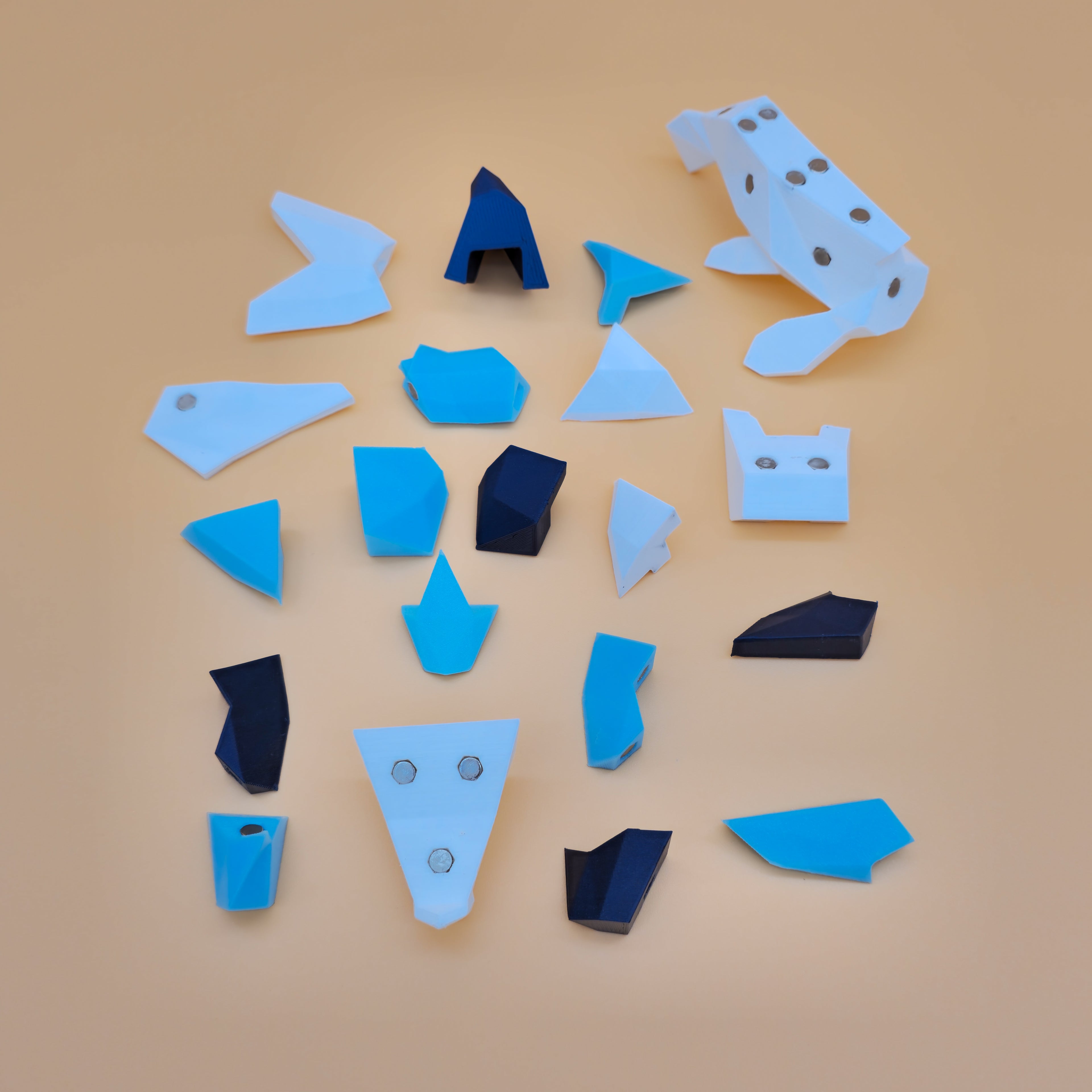 White, dark metallic blue, and light blue magnetic puzzle pieces on a beige background