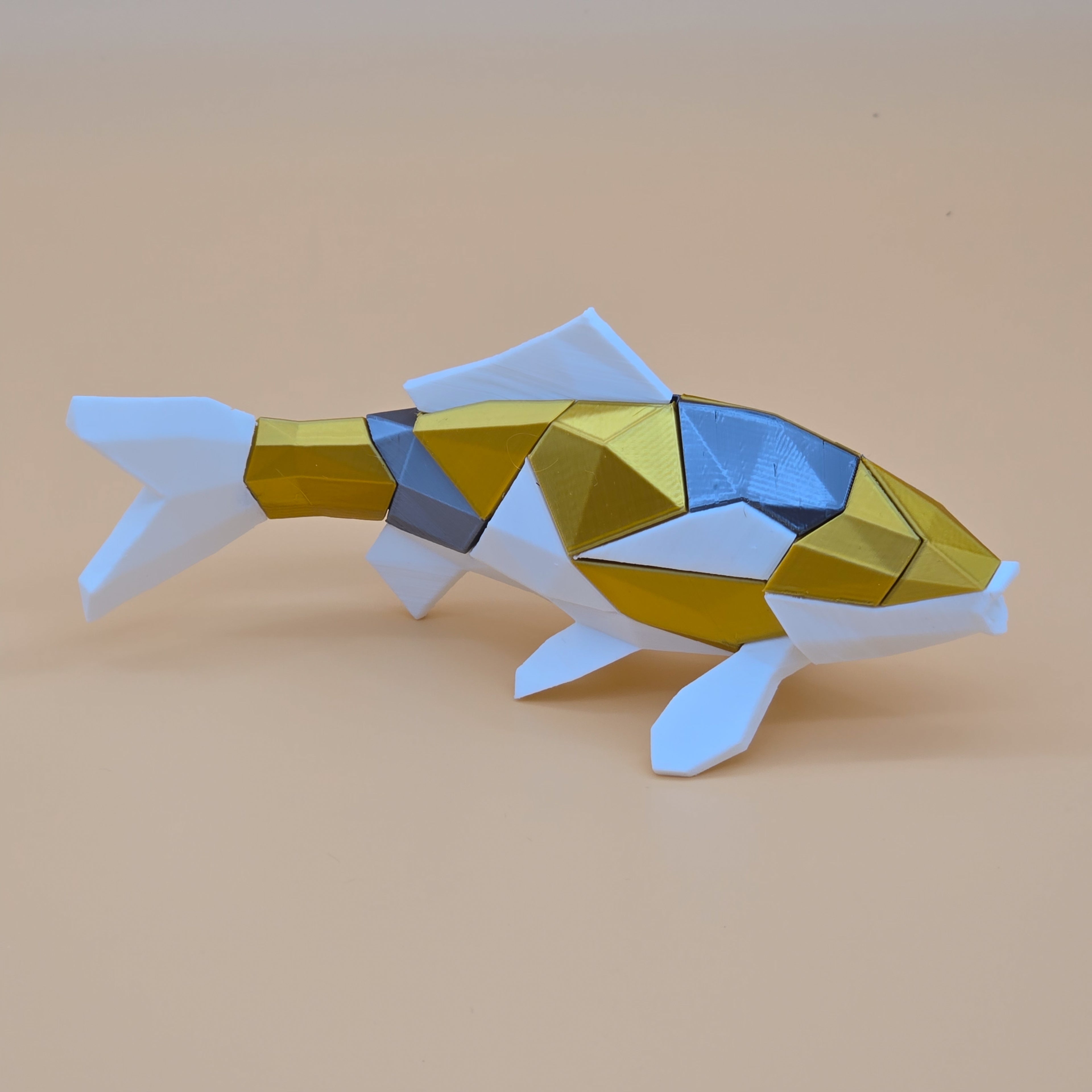 White, gold, and silver 3D printed magnetic koi puzzle on a beige background